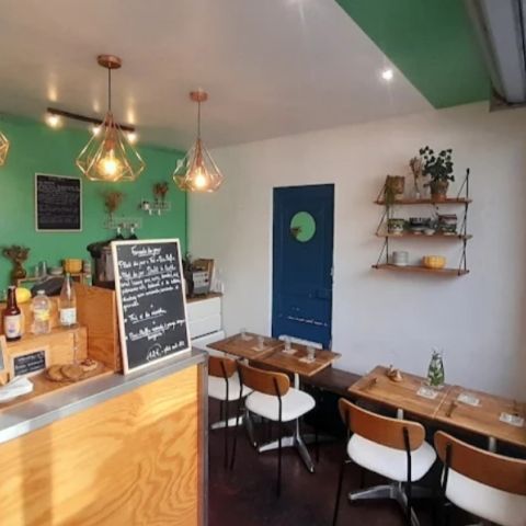 Intérieur du restaurant comprenant un comptoir central et quelques tables et chaises.